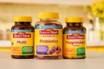 Three Nature Made supplement bottles: Multi vitamin, Probiotics gummies, and Magnesium Glycinate, displayed on a table with a blurred background.